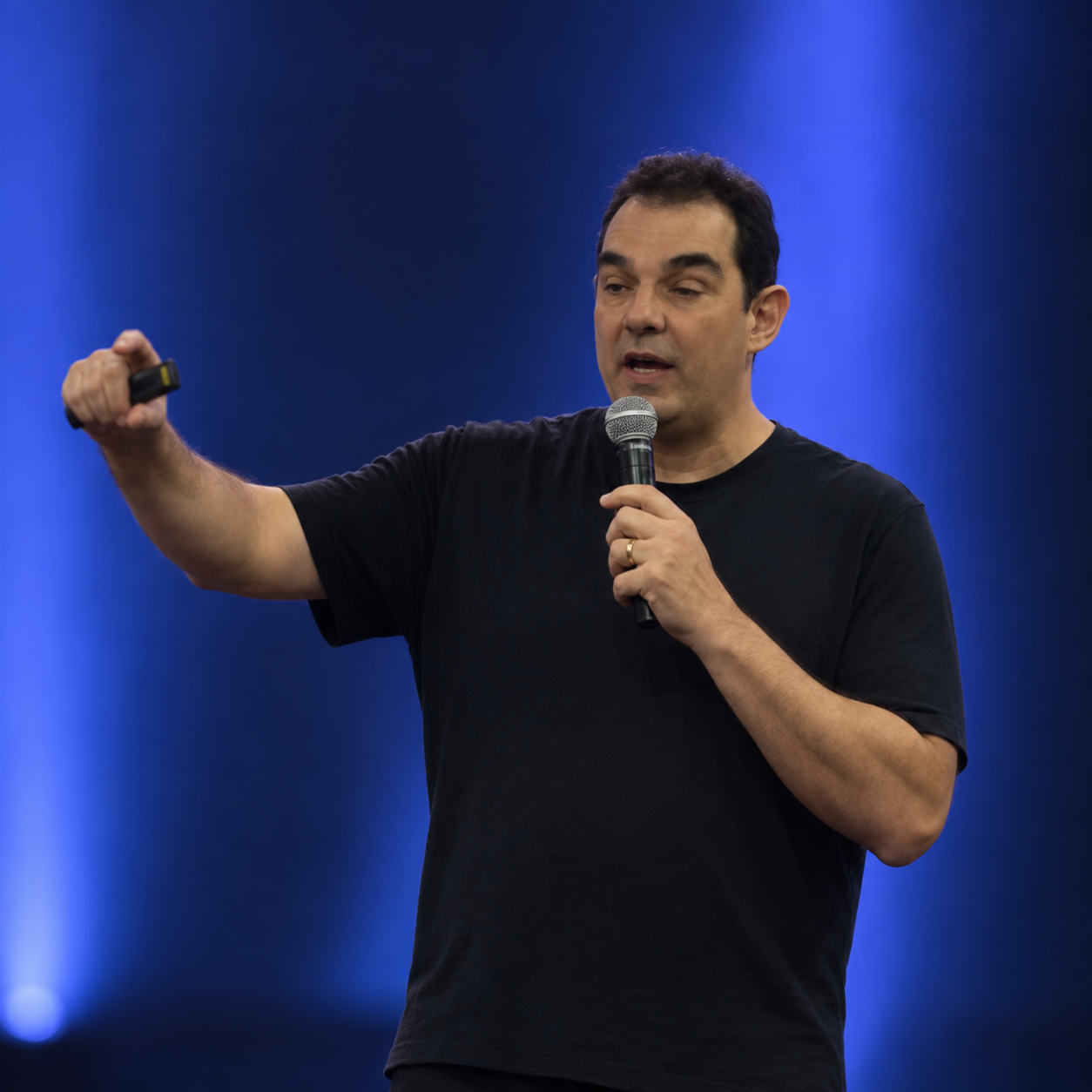 Victor Mirshawka Jr. palestrando, com microfone e controle de apresentação